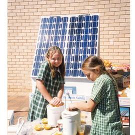 Students using a solar-powered juicer during a school visit 