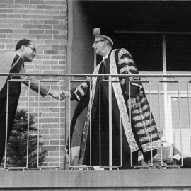 The Chancellor W.C. Wurth shaking hands with a graduate.