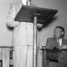 Joseph O.A. Bourke (Bursar) standing at lectern. 